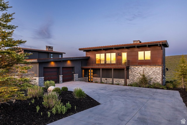 6836 Golden Bear Loop W, Park City, UT 84098 - view of front of house featuring stone siding, a balcony, driveway, and a chimney