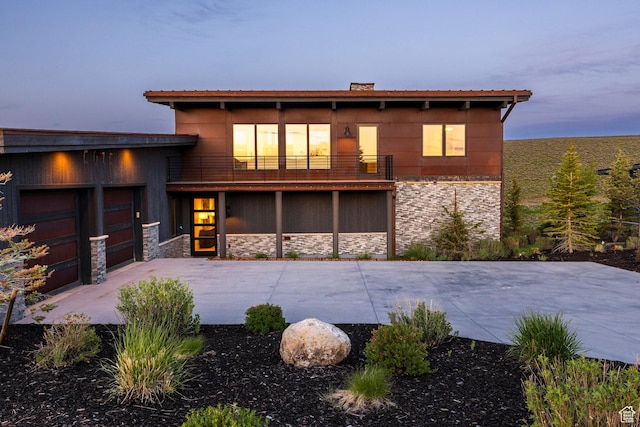6836 Golden Bear Loop W, Park City, UT 84098 - back of house at dusk featuring stone siding, a balcony, and driveway