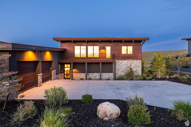 6836 Golden Bear Loop W, Park City, UT 84098 - view of front of home with stone siding, a balcony, an attached garage, and driveway