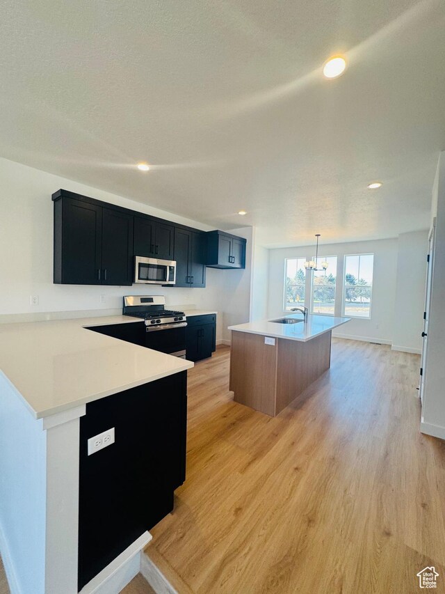 1650 N Main St Unit 126, Layton, UT 84041 - kitchen featuring appliances with stainless steel finishes, dark cabinetry, light countertops, a chandelier, and recessed lighting