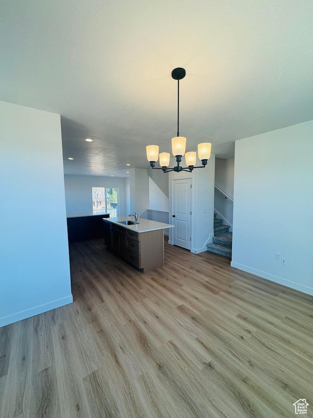 1650 N Main St Unit 126, Layton, UT 84041 - kitchen with open floor plan, light wood-style flooring, a kitchen island with sink, light countertops, and a chandelier