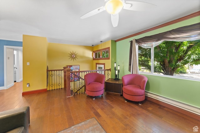 684 N Mccormick Blvd, Moab, UT 84532 - living area with baseboard heating, wood-type flooring, a ceiling fan, and an upstairs landing