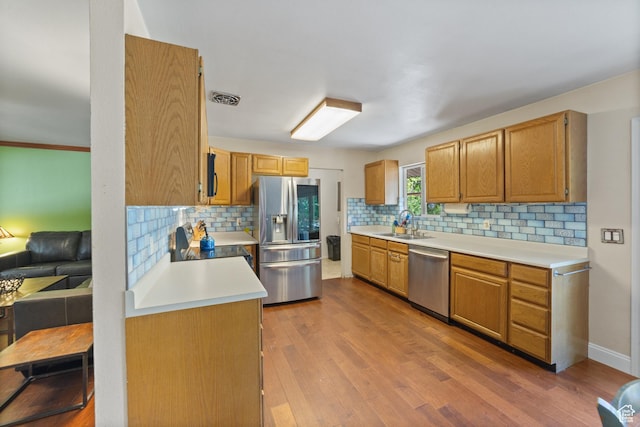 684 N Mccormick Blvd, Moab, UT 84532 - kitchen featuring appliances with stainless steel finishes, backsplash, light countertops, and wood finished floors