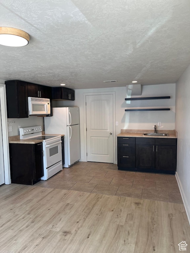 1194 W 400 S, Orem, UT 84058 - kitchen with white appliances, light wood finished floors, open shelves, dark cabinets, and a textured ceiling