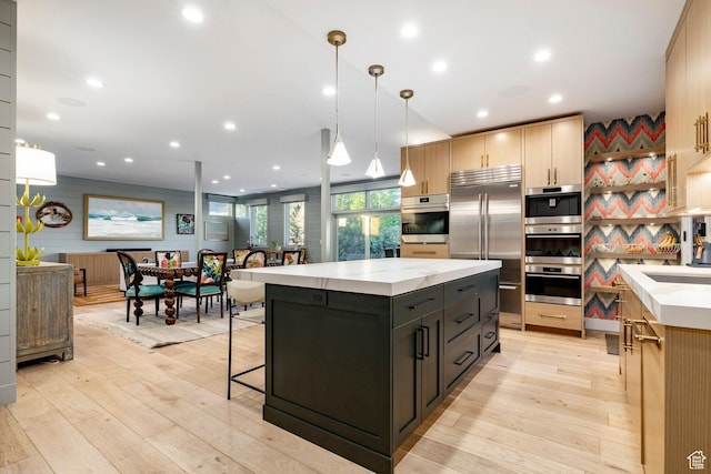 4746 Old Meadow Ln, Park City, UT 84098 - kitchen with stainless steel appliances, a kitchen island, light wood-style flooring, hanging light fixtures, and recessed lighting