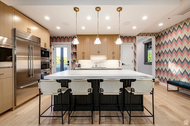 4746 Old Meadow Ln, Park City, UT 84098 - kitchen with built in refrigerator, wallpapered walls, light countertops, light wood-style floors, and a kitchen island