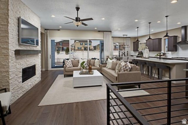 243 E Polaris Dr Unit 106, Saratoga Springs, UT 84045 - living room with ceiling fan, recessed lighting, a stone fireplace, plenty of natural light, and dark wood-style floors