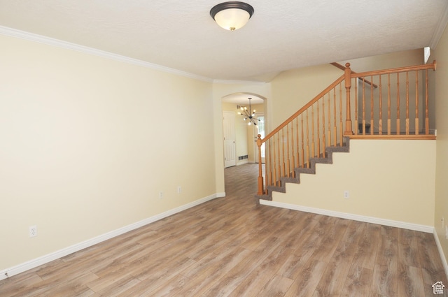 1511 W Leonardo Ln Unit D, West Valley City, UT 84119 - staircase with a chandelier, arched walkways, wood finished floors, and ornamental molding