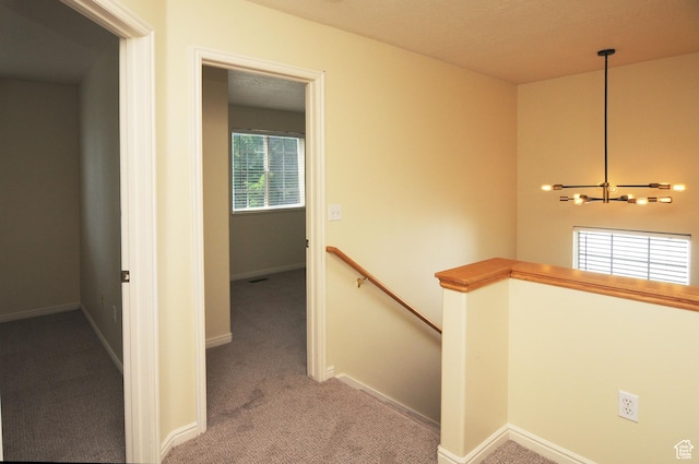 1511 W Leonardo Ln Unit D, West Valley City, UT 84119 - corridor with an upstairs landing, carpet flooring, and a chandelier