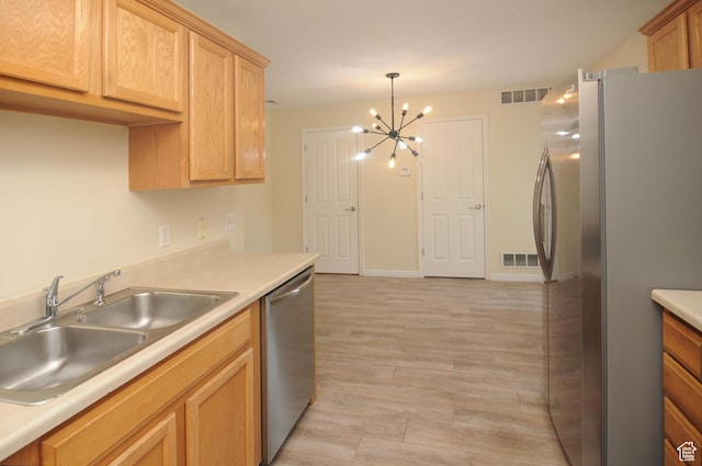 1511 W Leonardo Ln Unit D, West Valley City, UT 84119 - kitchen with stainless steel appliances, a chandelier, light countertops, and light wood-type flooring