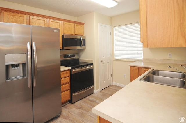 1511 W Leonardo Ln Unit D, West Valley City, UT 84119 - kitchen with appliances with stainless steel finishes, light wood finished floors, and light countertops