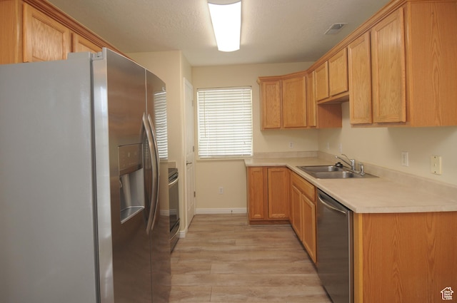 1511 W Leonardo Ln Unit D, West Valley City, UT 84119 - kitchen with stainless steel appliances, light wood finished floors, and light countertops