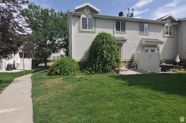 1511 W Leonardo Ln Unit D, West Valley City, UT 84119 - back of property featuring stucco siding and a lawn