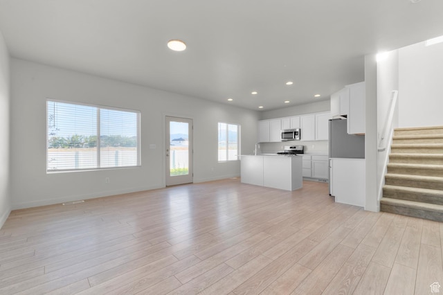 421 W Domain Ln, Grantsville, UT 84029 - unfurnished living room with light wood finished floors, stairs, and recessed lighting