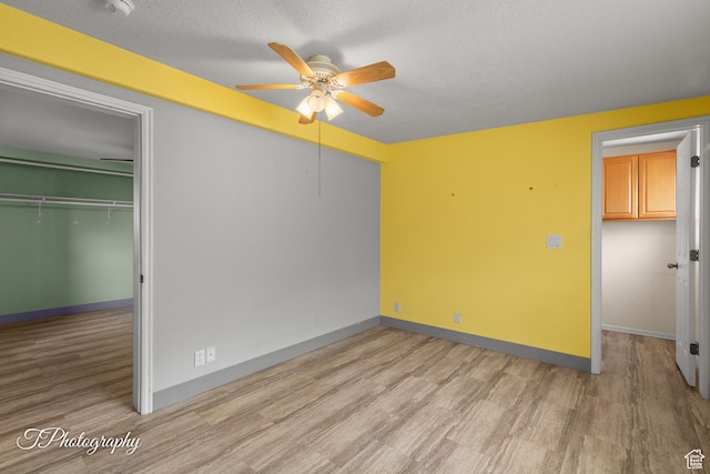1160 E Telegraph Unit 227, Washington, UT 84780 - unfurnished bedroom featuring light wood-style floors, a textured ceiling, and ceiling fan