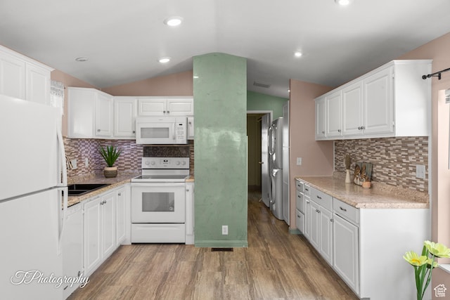 1160 E Telegraph Unit 227, Washington, UT 84780 - kitchen featuring white appliances, lofted ceiling, white cabinets, light wood-style floors, and backsplash