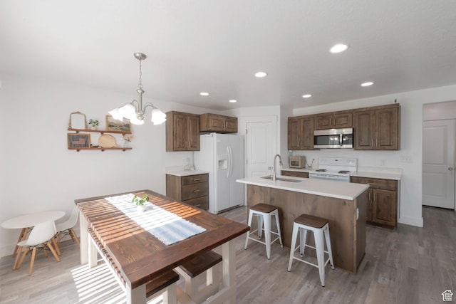 721 S 110 W, Spanish Fork, UT 84660 - kitchen featuring white appliances, a chandelier, light countertops, light wood-style flooring, and recessed lighting
