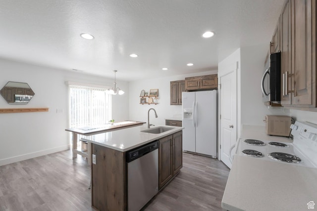 721 S 110 W, Spanish Fork, UT 84660 - kitchen featuring white appliances, light wood-type flooring, light countertops, an island with sink, and recessed lighting