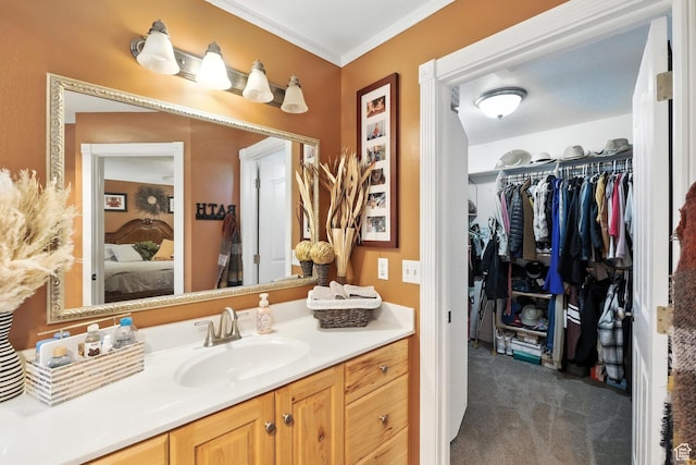 1680 N Camelot Dr E, North Logan, UT 84341 - bathroom featuring vanity, ensuite bathroom, a walk in closet, and ornamental molding