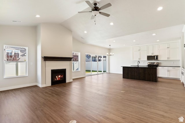 339 N 3250 W Unit 12, West Point, UT 84015 - unfurnished living room featuring vaulted ceiling, a ceiling fan, a lit fireplace, light wood-type flooring, and recessed lighting