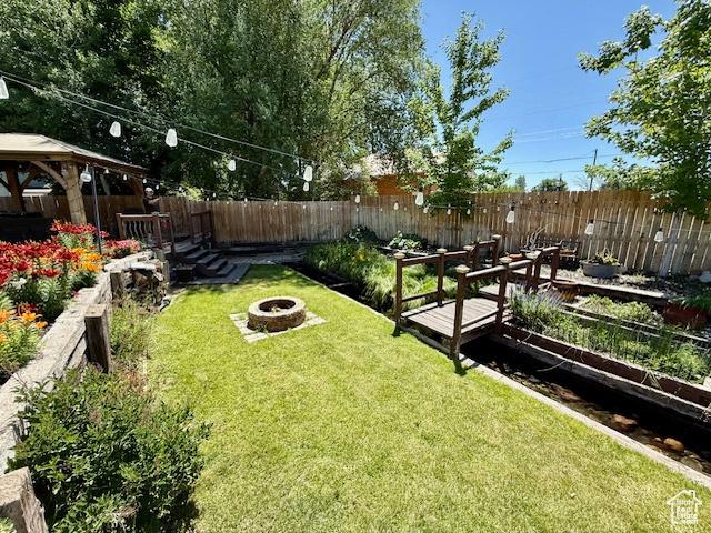 536 N Sundance Cir, Vernal, UT 84078 - fenced backyard featuring an outdoor fire pit, a gazebo, and a garden