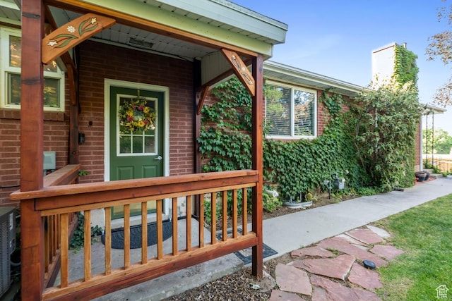 2793 S Davis Blvd, Bountiful, UT 84010 - view of exterior entry with brick siding, a chimney, and covered porch