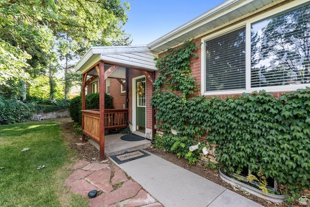 2793 S Davis Blvd, Bountiful, UT 84010 - doorway to property with brick siding, a yard, and covered porch