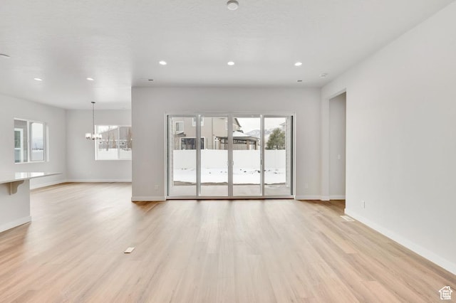 273 E Polaris Dr Unit 103, Saratoga Springs, UT 84045 - unfurnished living room featuring a chandelier, recessed lighting, and light wood-type flooring