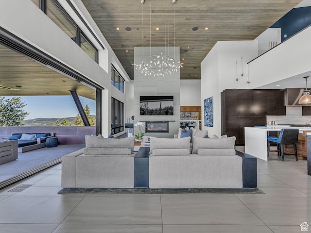 4693 Pinnacle Sky Loop, Park City, UT 84098 - living room with a towering ceiling, wood ceiling, a chandelier, light tile patterned flooring, and a large fireplace