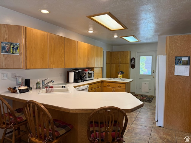 2936 E Ln Joya Dr S, Holladay, UT 84124 - kitchen featuring a peninsula, light countertops, white appliances, a breakfast bar area, and brown cabinetry