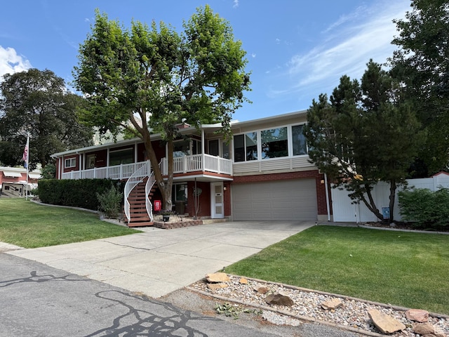 2936 E Ln Joya Dr S, Holladay, UT 84124 - view of front of property featuring stairs, a front lawn, covered porch, concrete driveway, and an attached garage