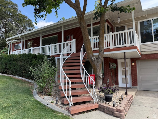 2936 E Ln Joya Dr S, Holladay, UT 84124 - view of front facade featuring brick siding, stairs, a porch, driveway, and an attached garage