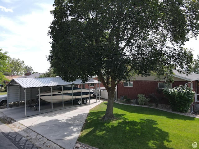 2936 E Ln Joya Dr S, Holladay, UT 84124 - view of property hidden behind natural elements featuring a front yard, brick siding, a detached carport, and driveway