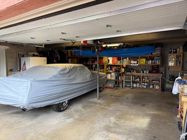 2936 E Ln Joya Dr S, Holladay, UT 84124 - garage with a workshop area, fridge, and concrete block wall
