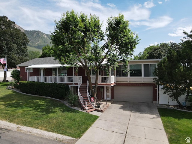 2936 E Ln Joya Dr S, Holladay, UT 84124 - view of front of house featuring a garage, driveway, a front lawn, stairway, and covered porch