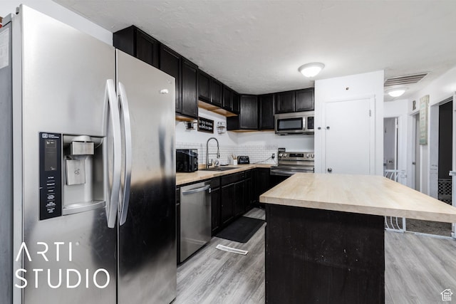 4370 S 175 E, Washington Terrace, UT 84405 - kitchen with appliances with stainless steel finishes, light wood-style floors, dark cabinets, tasteful backsplash, and a center island