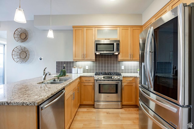 1988 S 1100 E Unit 308, Salt Lake City, UT 84105 - kitchen with stainless steel appliances, a peninsula, light wood-type flooring, tasteful backsplash, and light stone counters