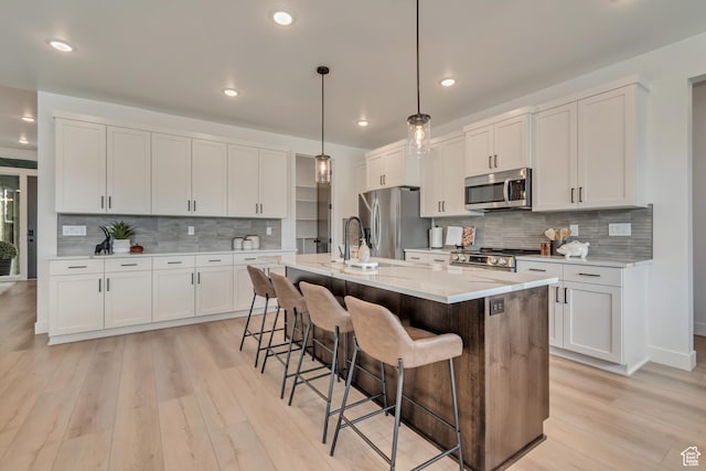 1282 N 1525 E Unit 68, Payson, UT 84651 - kitchen featuring appliances with stainless steel finishes, decorative backsplash, light wood-type flooring, a breakfast bar, and recessed lighting