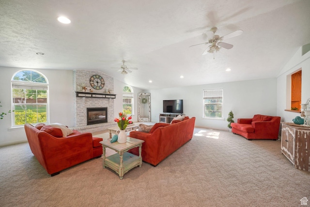 117 E 300 S, Gunnison, UT 84634 - living area featuring a ceiling fan, carpet floors, vaulted ceiling, healthy amount of natural light, and a stone fireplace