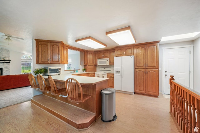 117 E 300 S, Gunnison, UT 84634 - kitchen with white appliances, light wood finished floors, ceiling fan, and brown cabinets