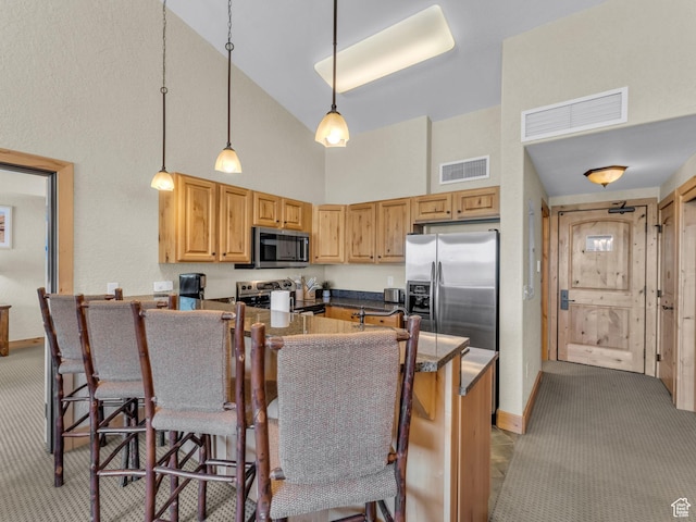 2653 Canyons Resort Dr Unit 420, Park City, UT 84098 - kitchen with appliances with stainless steel finishes, high vaulted ceiling, light colored carpet, a breakfast bar, and a peninsula