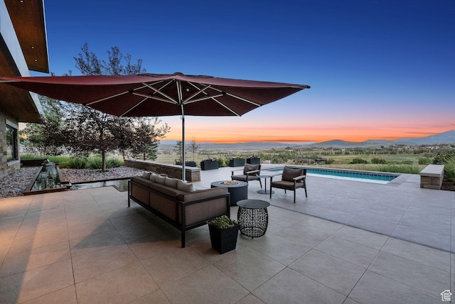 8078 N Red Fox Ct, Park City, UT 84098 - patio terrace at dusk with a patio area, an outdoor pool, and an outdoor living space with a fire pit