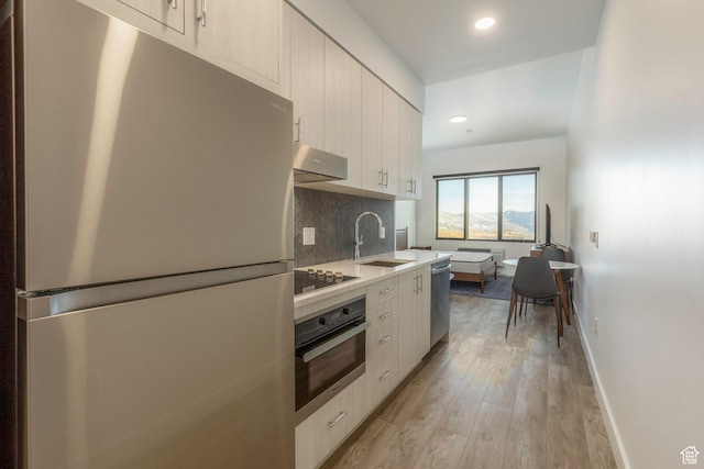 2303 Deer Hollow Rd Unit 2114, Park City, UT 84060 - kitchen with appliances with stainless steel finishes, decorative backsplash, light wood-type flooring, light countertops, and extractor fan