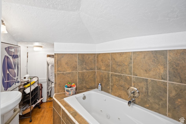 1639 20th S, Ogden, UT 84401 - bathroom featuring a jetted tub, a textured ceiling, and wood finished floors