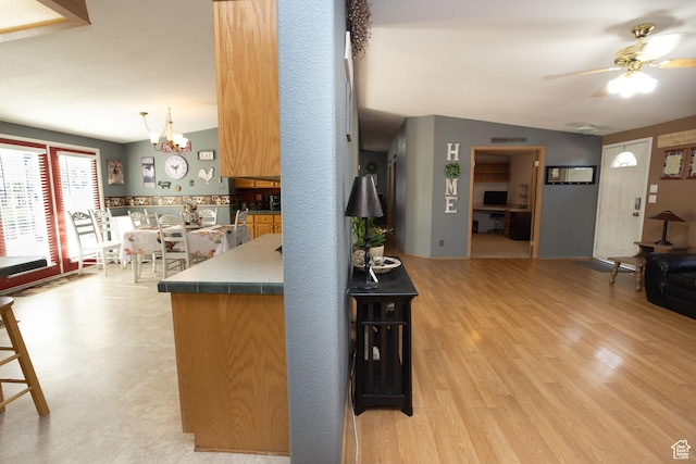 205 W 575 S, Venice, UT 84701 - kitchen featuring vaulted ceiling, ceiling fan, light wood finished floors, a chandelier, and dark countertops
