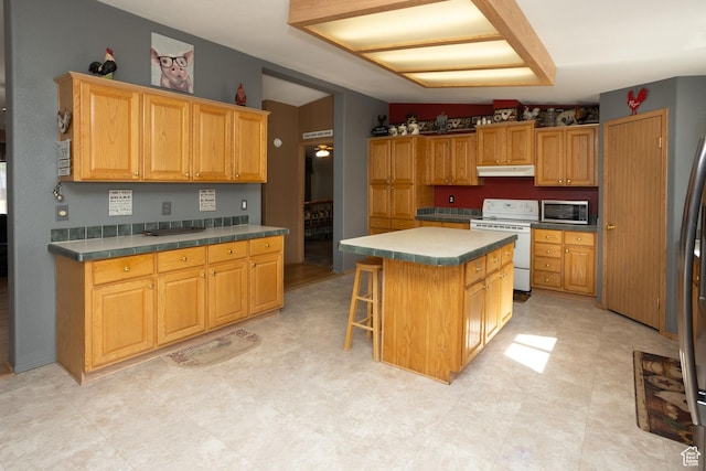 205 W 575 S, Venice, UT 84701 - kitchen with electric stove, under cabinet range hood, stainless steel microwave, a kitchen island, and a breakfast bar