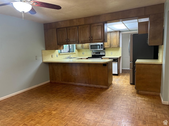 5681 S Calann Dr E, Holladay, UT 84121 - kitchen with appliances with stainless steel finishes, light countertops, a peninsula, ceiling fan, and backsplash