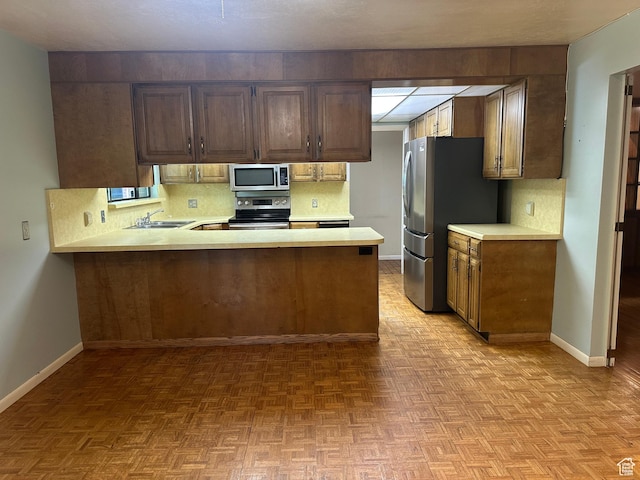 5681 S Calann Dr E, Holladay, UT 84121 - kitchen with stainless steel appliances, light countertops, backsplash, and a peninsula