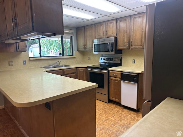 5681 S Calann Dr E, Holladay, UT 84121 - kitchen with appliances with stainless steel finishes, light countertops, a peninsula, and backsplash