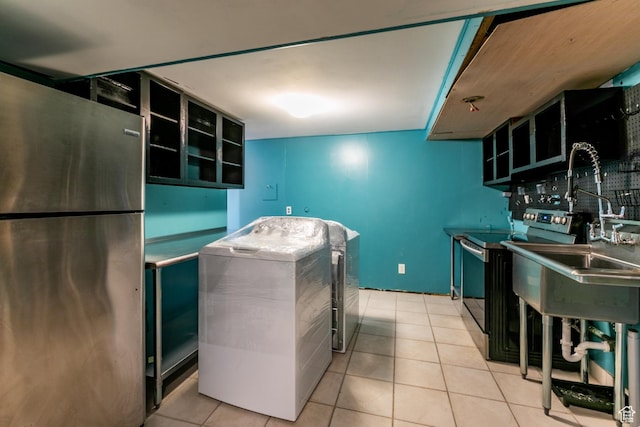 5681 S Calann Dr E, Holladay, UT 84121 - kitchen with appliances with stainless steel finishes, washer / dryer, and tile patterned floors